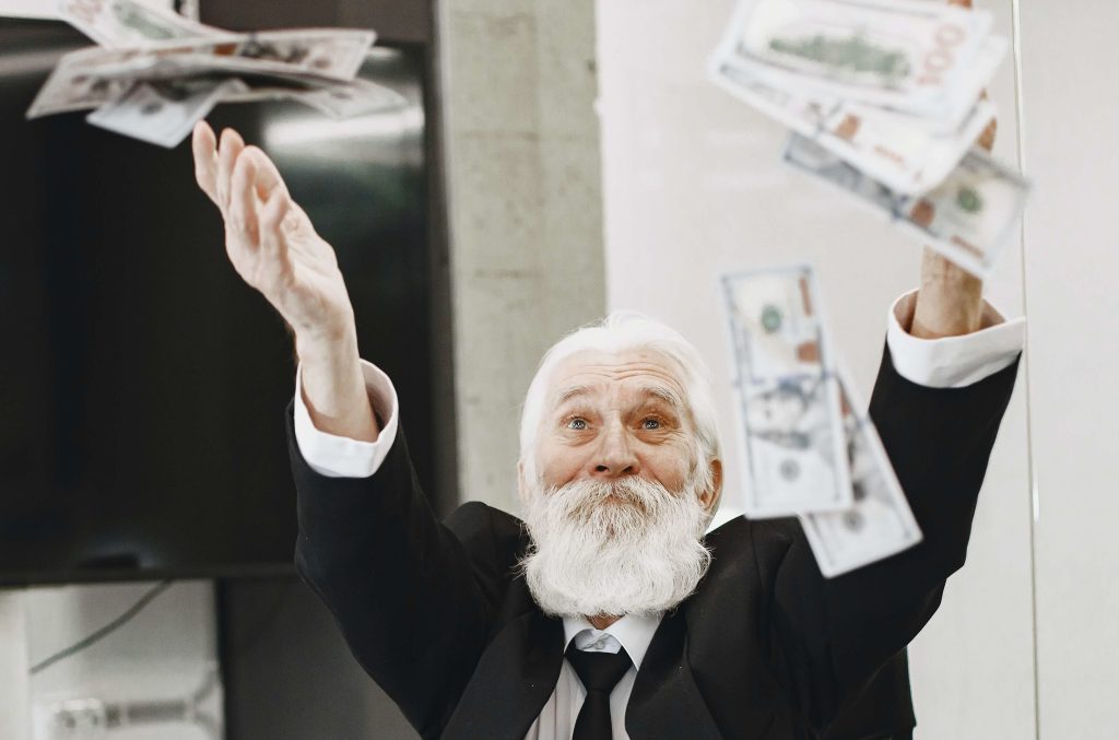 What should I charge as a service based business? An older man in a suit throwing money in the air