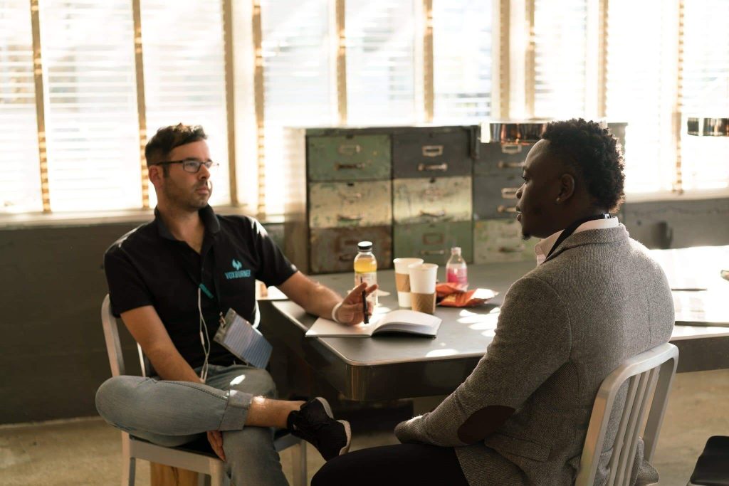 VAT Flat rate scheme basics - two men sitting at a table in an office with a notebook discussing