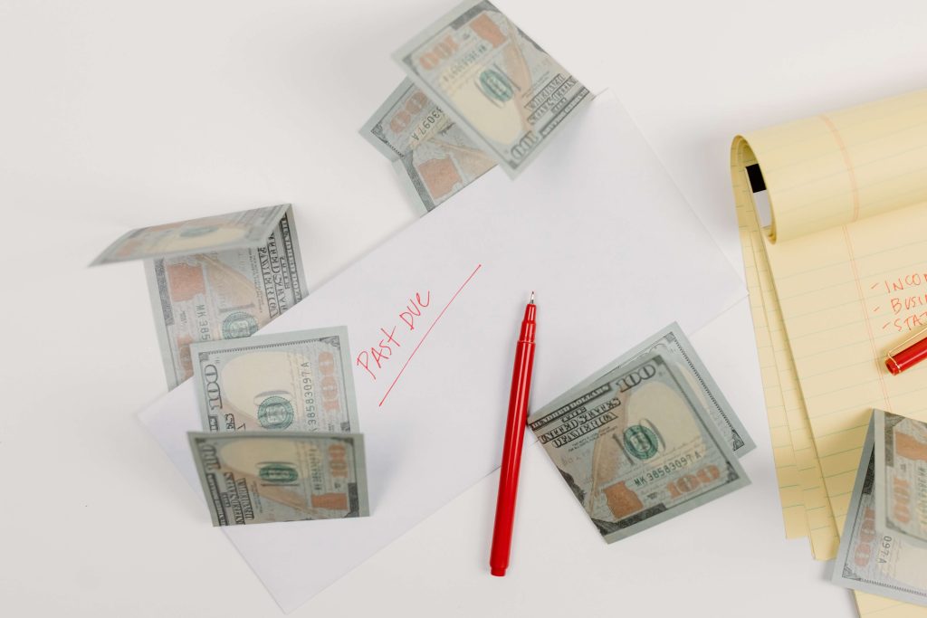 Key Limited Company Expenses - an envelope saying, "Past due", and some lose dollars on a white desk